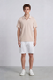 Front image of a model wearing Deep leroy polo in peach, by brand Deep