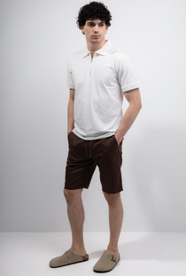 Front image of a model wearing the Deep premium polo in white, by brand Deep