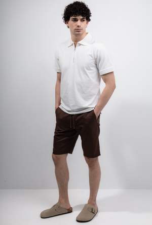 Front image of a model wearing the Deep premium polo in white, by brand Deep