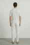 Back image of a model wearing the Deep rory open neck polo in white, by brand Deep