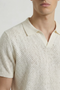 Front detail image of a model wearing the Deep ryker open neck polo in beige, by brand Deep