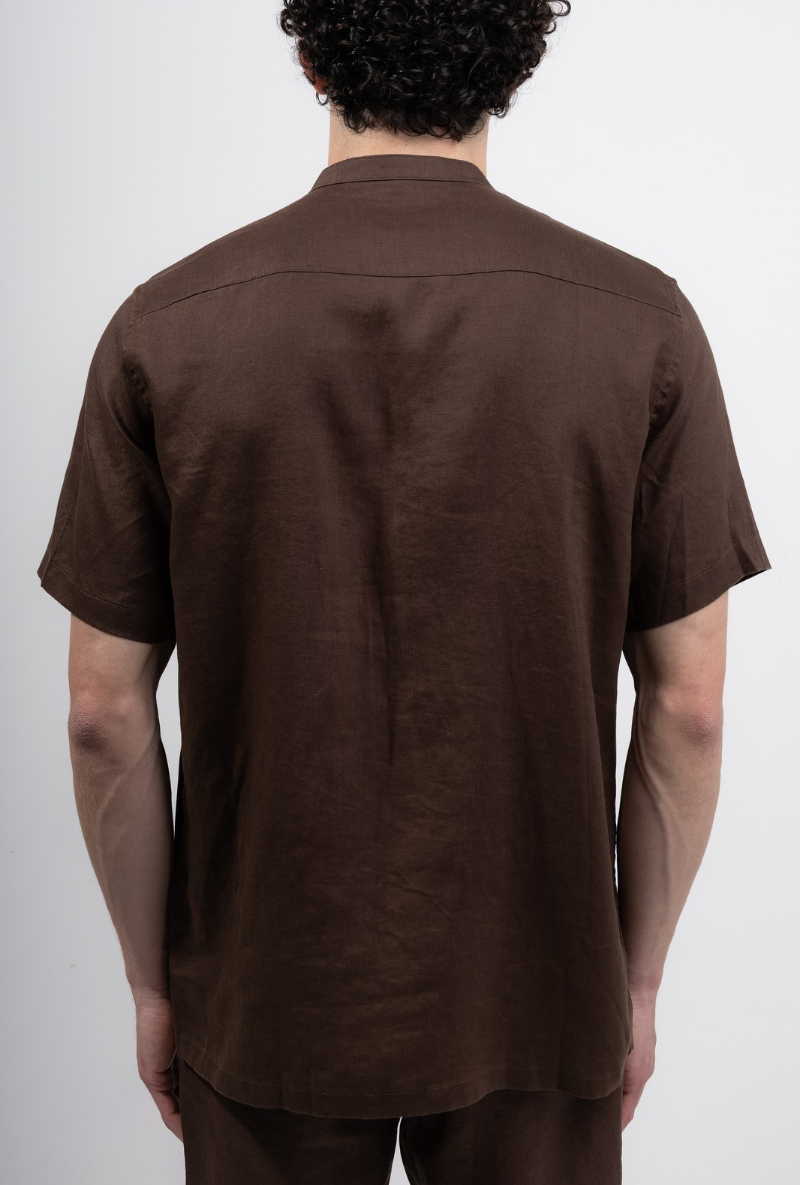 Back image of a model wearing Deep strike linen shirt in brown, by brand Deep