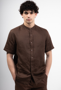 Front image of a model wearing the Deep strike linen shirt in brown, by brand Deep