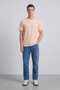 Front image of a model wearing the Deep troy s/s tshirt in peach, by brand Deep