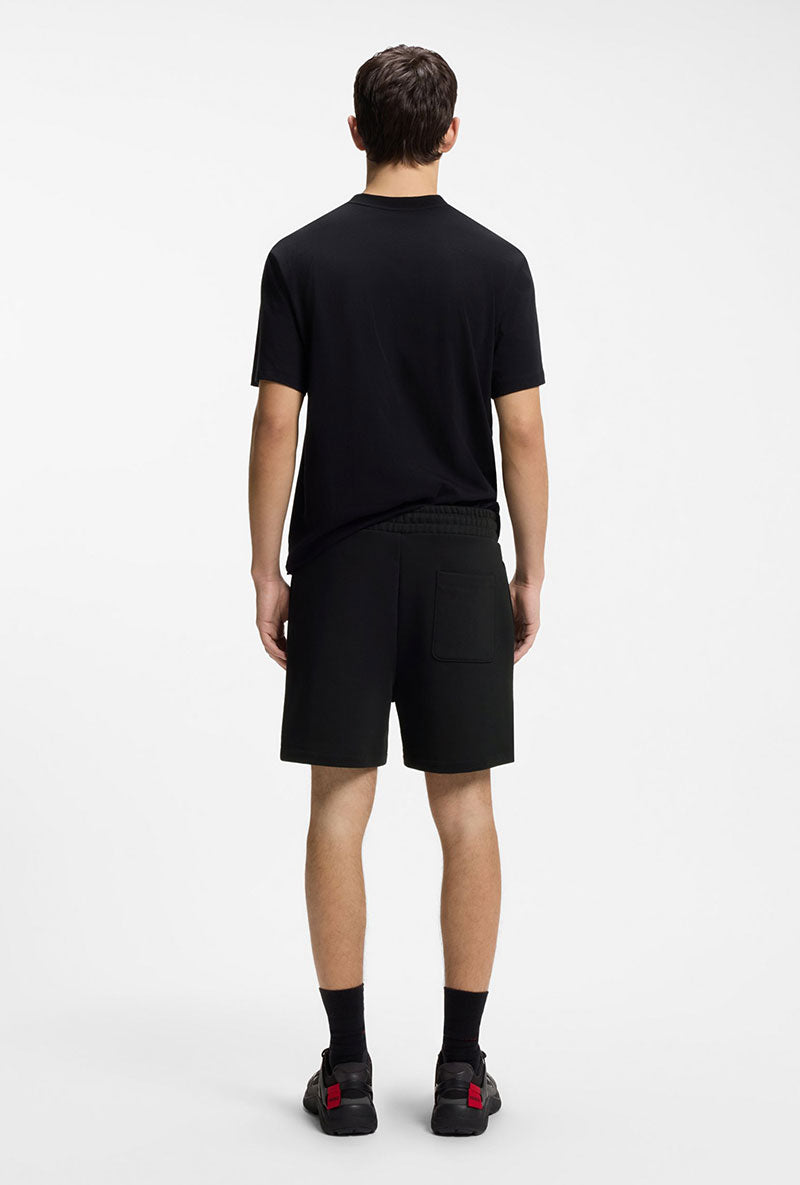 Back image of a model wearing Dagety sweat shorts in black, by brand Hugo