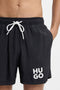 Front image of a model wearing the Paolo swimshorts in black, by brand Hugo