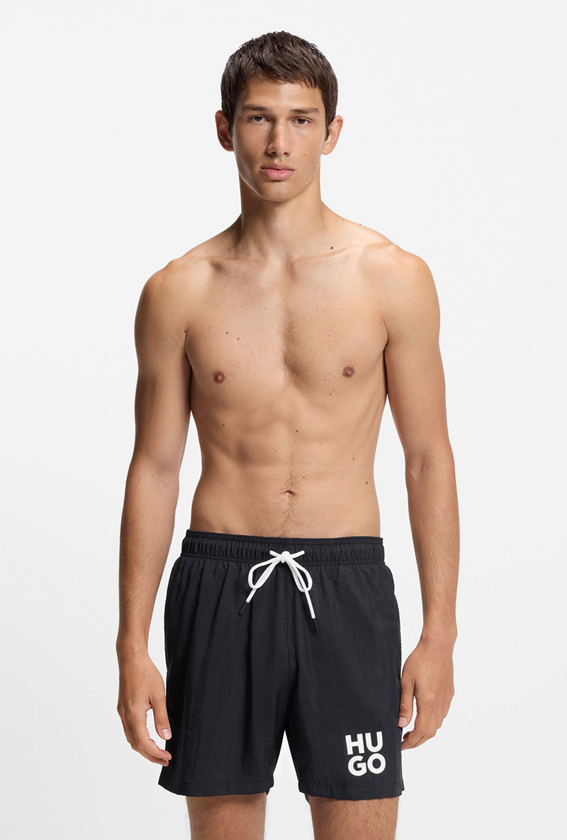 Front image of a model wearing Paolo swimshorts in black, by brand Hugo