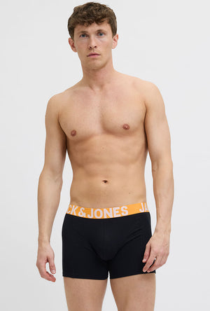 Front image of a model wearing the Jack and jones solid 3 pk trunks in black, by brand Jack&jones