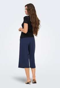 Back image of a model wearing the Catie s/s assymetric top in black, by brand Jacqueline de yong