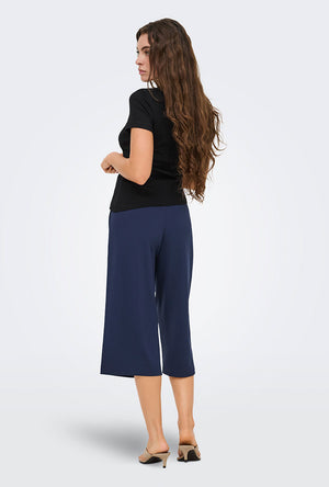 Back image of a model wearing the Catie s/s assymetric top in black, by brand Jacqueline de yong