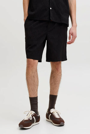 Front image of a model wearing the Jaiden wavy jogger shorts in black, by brand Jack&jones