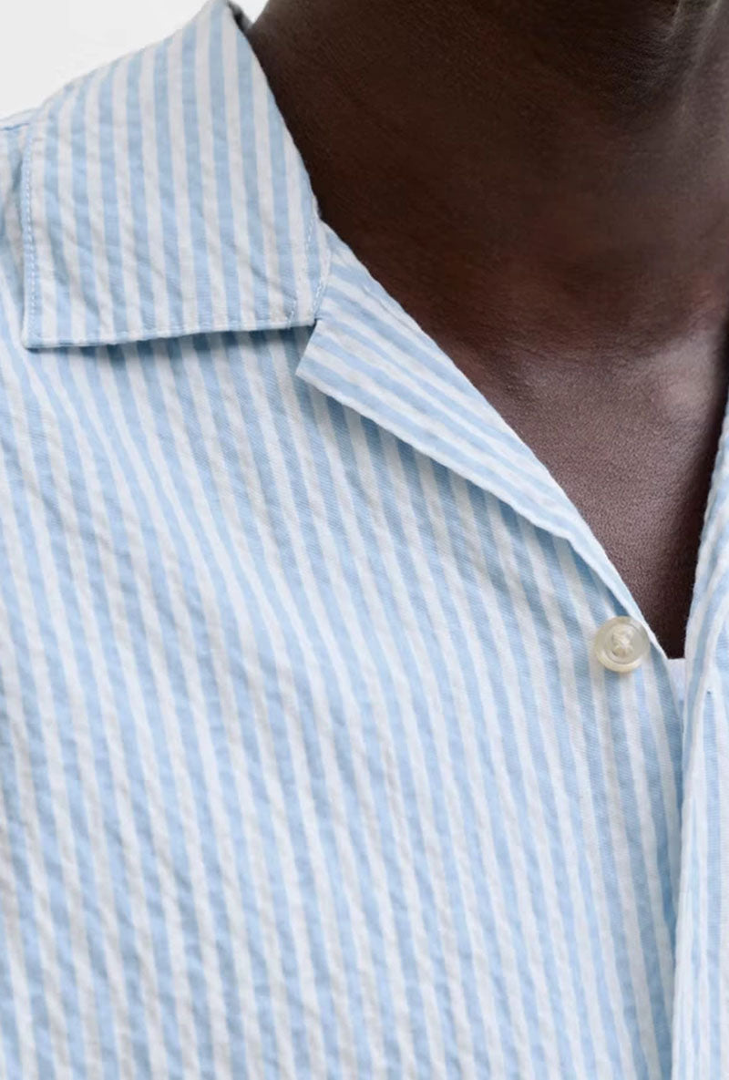 Neck detail image of a model wearing Milo seersucker resort shirt in light blue, by brand Jack&jones