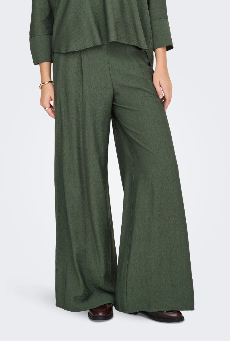 Close up image of a model wearing Jdy pepper palazzo pants in olive, by brand Jacqueline de yong
