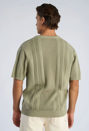 Back image of a model wearing the Knitted s/s polo in light green, by brand Lindbergh