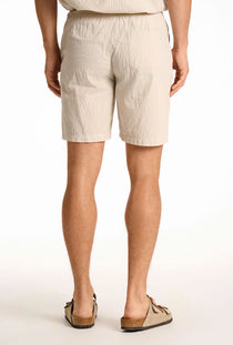 Back image of a model wearing the Seersucker shorts in beige, by brand Lindbergh