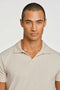 Front image of a model wearing the Stretch s/s polo shirt in stone, by brand Lindbergh