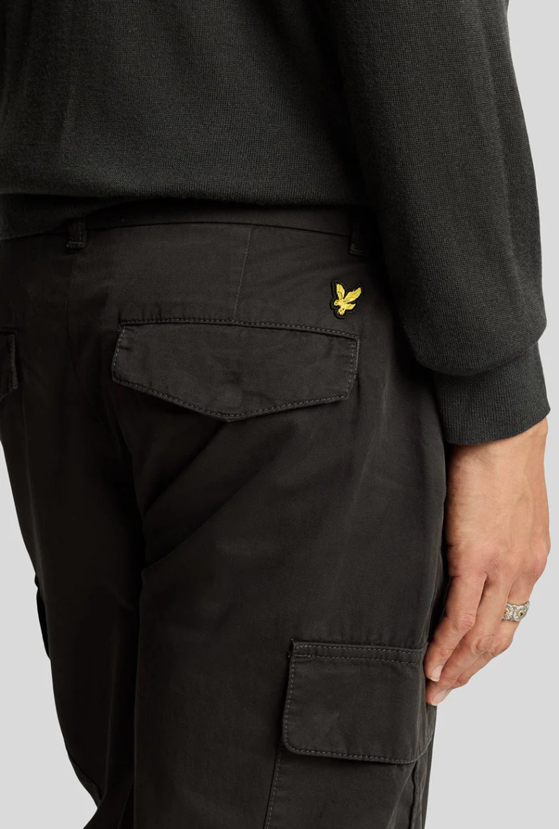 Back detail image of a model wearing Lyle and scott cargo pocket trousers in black, by brand Lyle and scott
