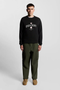 Front image of a model wearing Lyle and scott cheers to tradition sweatshirt in black, by brand Lyle and scott