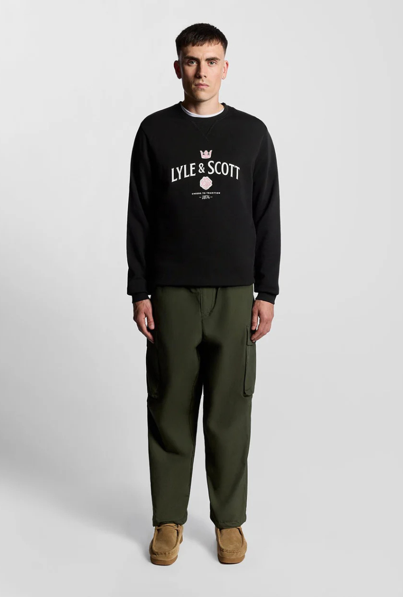 Front image of a model wearing Lyle and scott cheers to tradition sweatshirt in black, by brand Lyle and scott