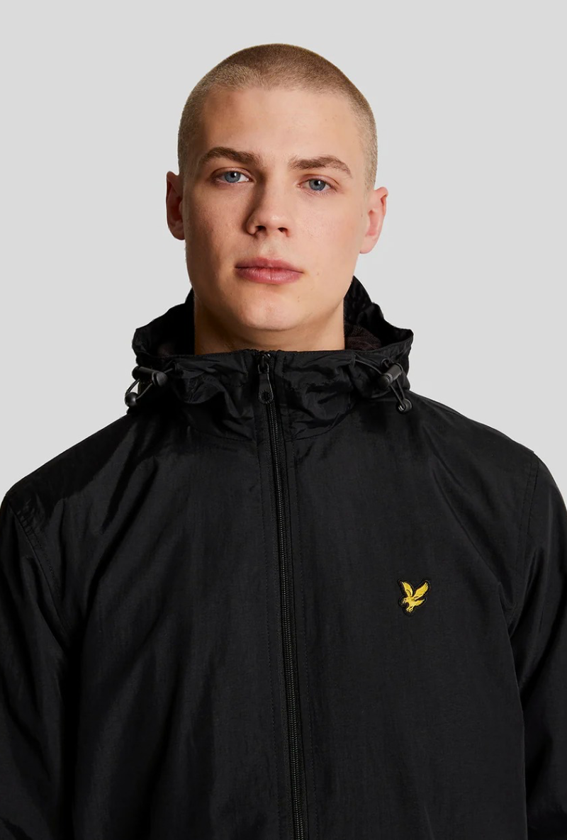 Front image of a model wearing Lyle and scott zip through hooded jacket in black, by brand Lyle and scott