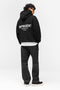 Back image of a model wearing the Owners club hoodie in black, by brand Represent