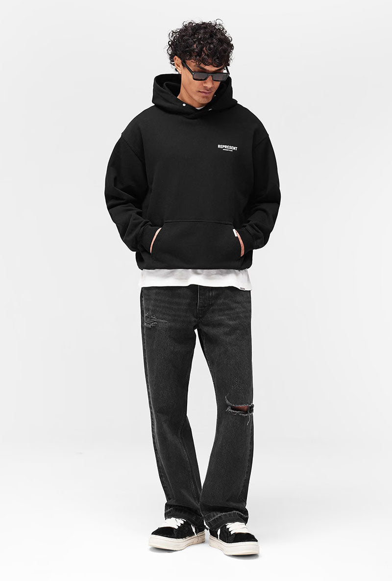 Front image of a model wearing Owners club hoodie in black, by brand Represent