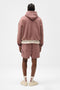 Back image of a model wearing the Owners club script mesh shorts in brown, by brand Represent