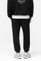 Back image of a model wearing the Owners club sweatpant in black, by brand Represent