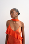 Front image of a model wearing the Annika ruffle maxi dress in rust, by brand Top shop