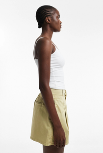 Front detail image of a model wearing the Eva a line shorts in sage, by brand Top shop