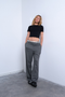 Front image of a model wearing Everyday crop top in black, by brand Top shop
