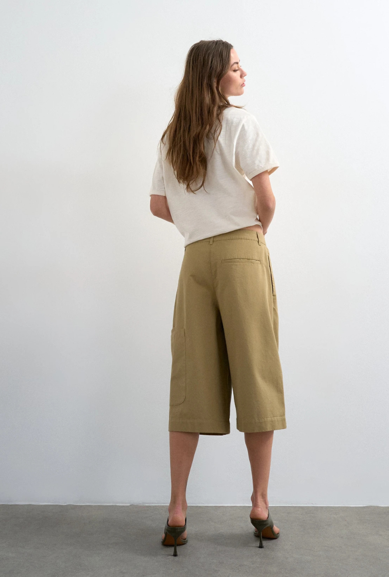 Back image of a model wearing Femke longline cargo shorts in tan, by brand Top shop