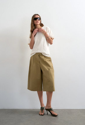 Front image of a model wearing Femke longline cargo shorts in tan, by brand Top shop