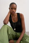 Front image of a model wearing the Honey vest in black, by brand Top shop
