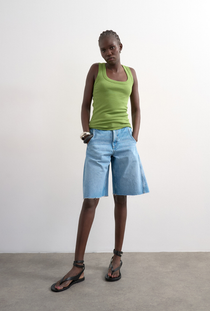 Front image of a model wearing the Honey vest in green, by brand Top shop