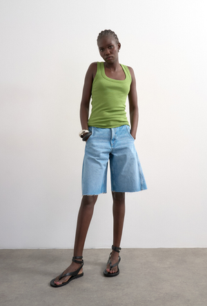 Front image of a model wearing the Honey vest in green, by brand Top shop