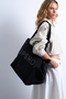 Front image of a model wearing the Ivy tote bag in black, by brand Top shop