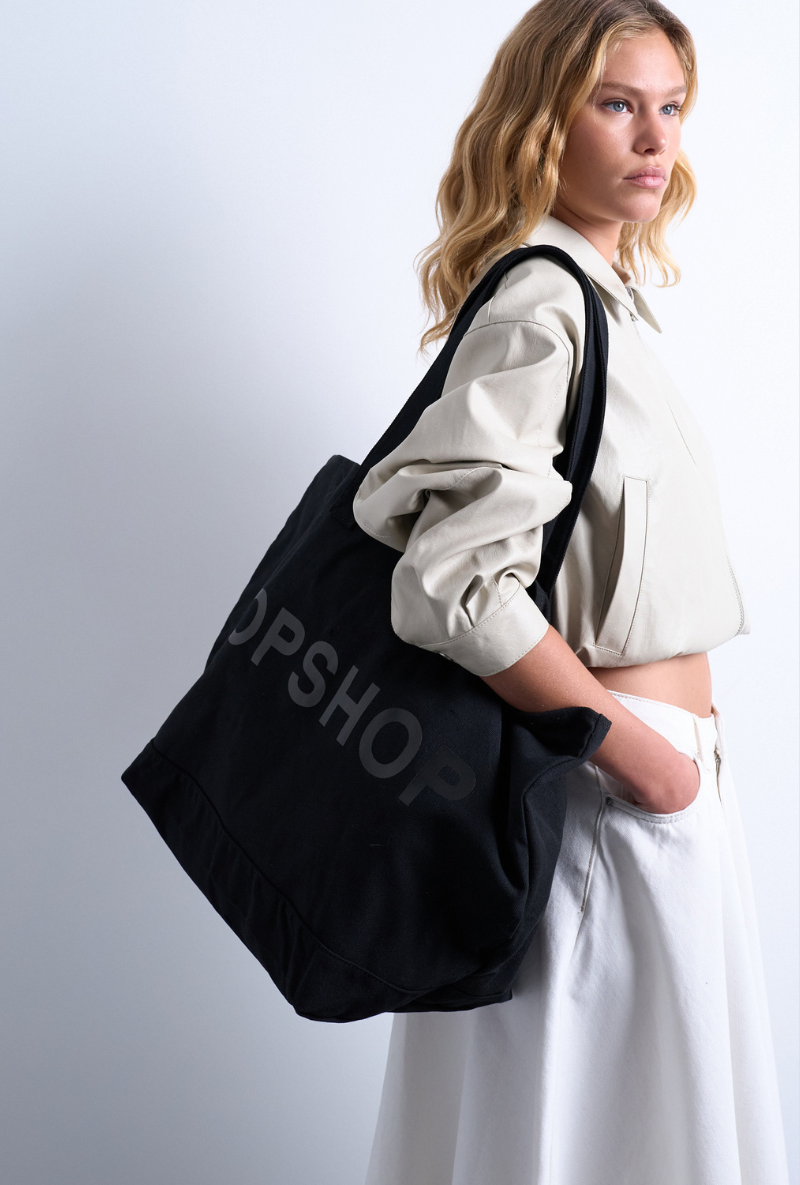 Front image of a model wearing Ivy tote bag in black, by brand Top shop