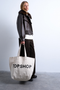 Front image of a model wearing the Ivy tote bag in white, by brand Top shop