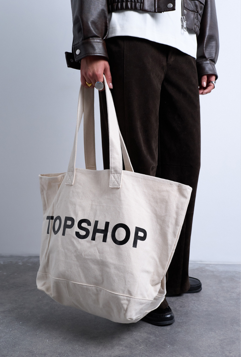 Front image of a model wearing Ivy tote bag in white, by brand Top shop
