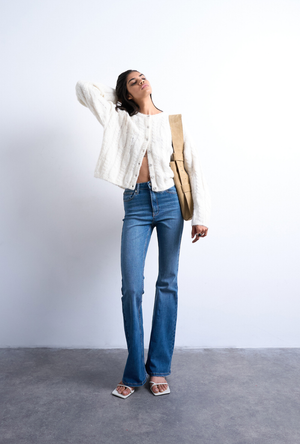 Front image of a model wearing the Jamie high rise flared jeans in denim, by brand Top shop