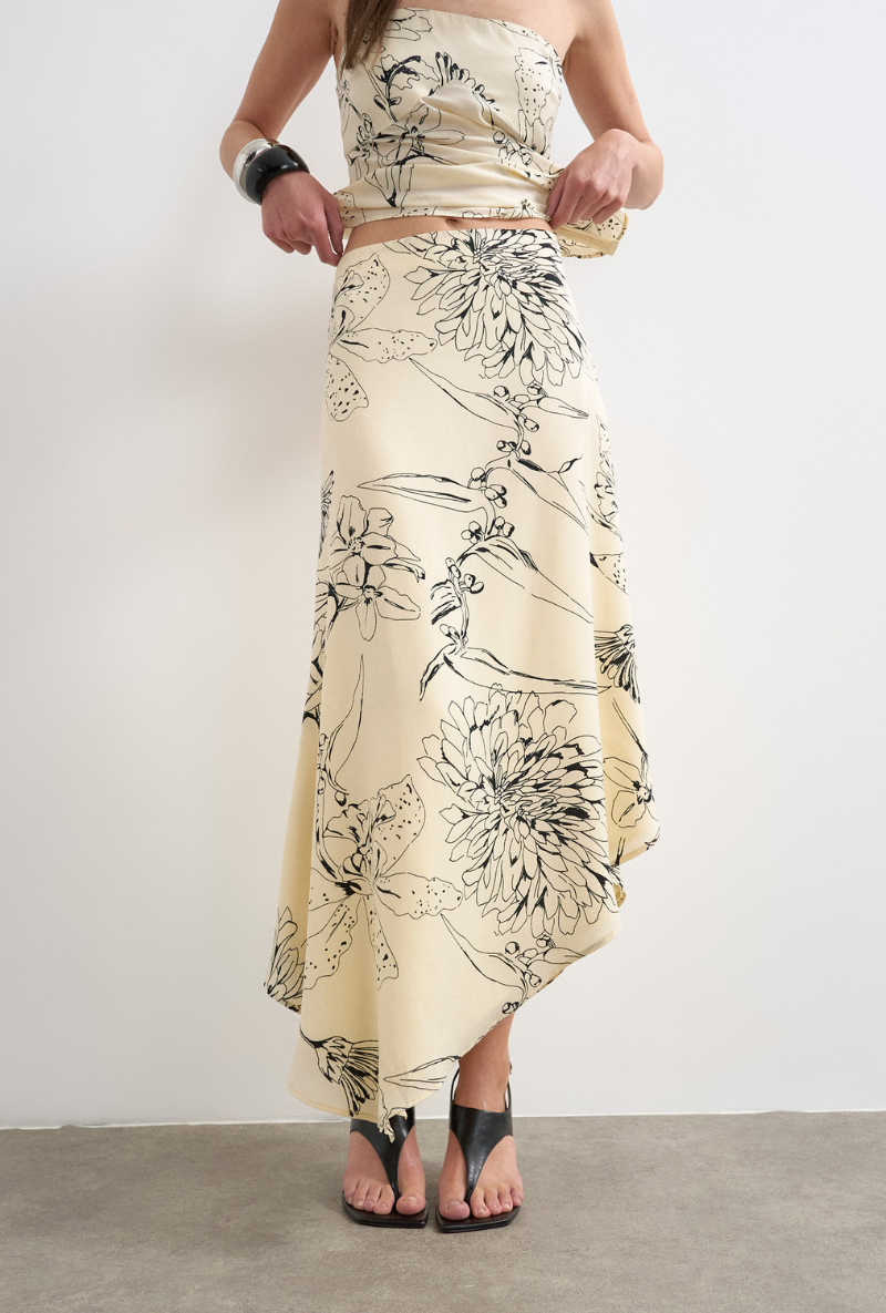 Front image of a model wearing Mani asymmetric slip skirt in cream, by brand Top shop