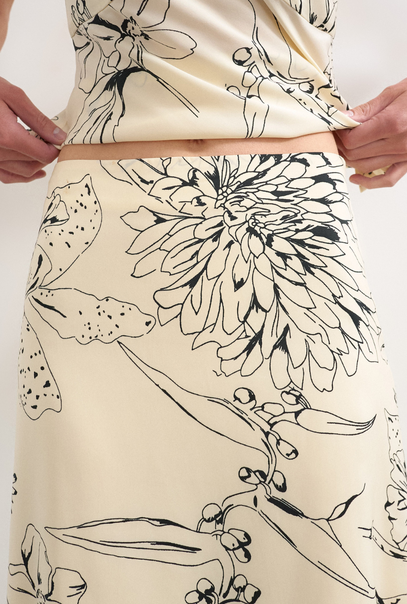 Front detail image of a model wearing Mani asymmetric slip skirt in cream, by brand Top shop