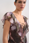 Front image of a model wearing the Rikke ruffle mini dress in brown, by brand Top shop