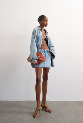 Front image of a model wearing Silje mini denim skirt in denim, by brand Top shop