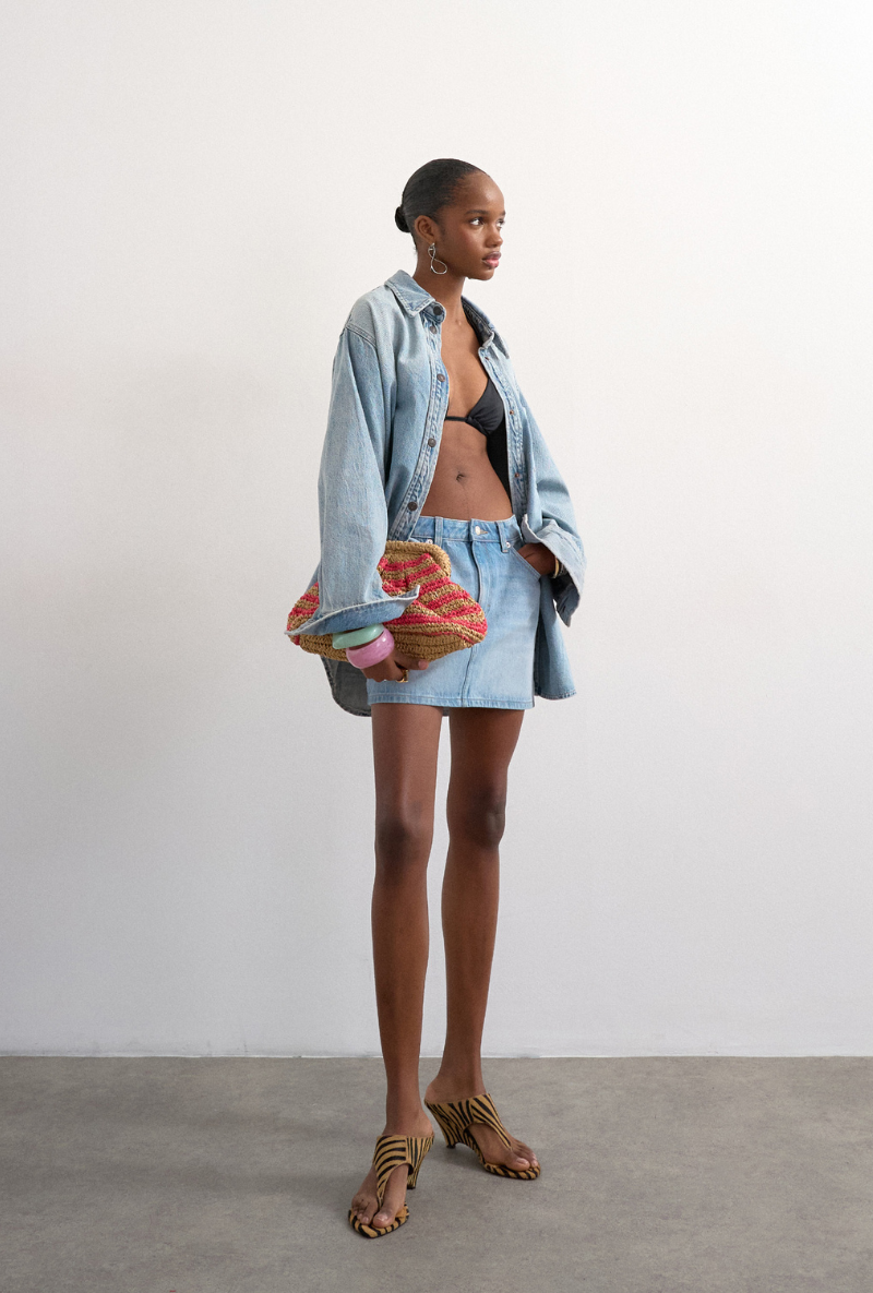 Front image of a model wearing Silje mini denim skirt in denim, by brand Top shop