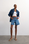 Front image of a model wearing Vigga denim shorts in denim, by brand Top shop