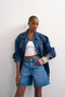 Front image of a model wearing the Vigga denim shorts in denim, by brand Top shop
