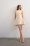 Front image of a model wearing Zenia mini dress in ecru, by brand Top shop