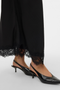 Close up image of a model wearing the Vero moda julia hw lace maxi skirt in black, by brand Vero moda